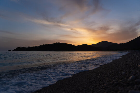 Golden hour. Evening relax. Golden sunset on seashore. Mountain sunset gold. Mountains sea and sunset