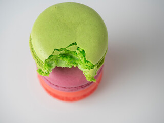bright colorful delicious macaroons lie piled on top of each other on a white background. One of...