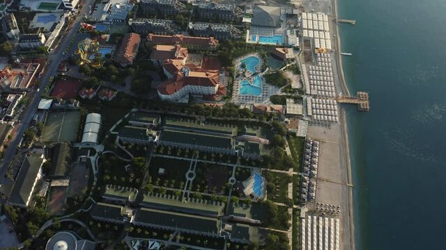 Aerial top view resorts in Kiris. Coastline with luxury hotels with pools and umbrellas on the beach in Kemer, Turkey