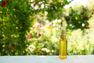 Oil serum for skin or hair care in bottle with nature background, natural organic cosmetic
