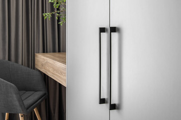 Elegant grey Scandinavian style chair and minimal wood console table in trendy bedroom interior of grey tones