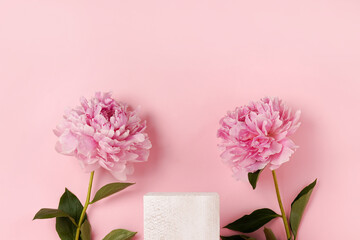 Cosmetics product advertising stand. Exhibition white podium with flowers peonies on a pink...