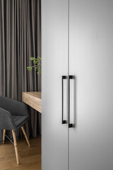 Elegant mirror on wooden frame wall above minimal wood console table in trendy bedroom interior of grey tones