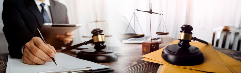 Justice and law concept.Male judge in a courtroom with the gavel, working with, computer and docking keyboard, eyeglasses, on table in morning light