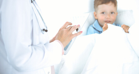 Happy smiling male kid-patient at usual medical inspection. Doctor and young boy in the clinic. Medicine concepts