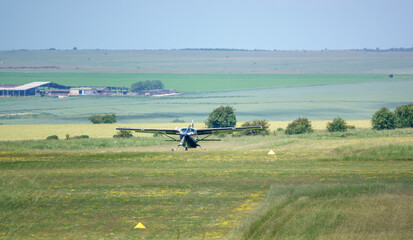 Naklejka na ściany i meble a light aircraft taking off from a grass runway of an army airfield on Salisbury Plain, Wiltshire