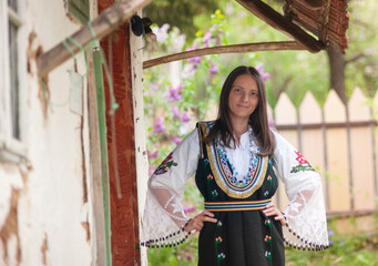 A young woman is posing in a traditional Serbian handmade outfit Litak (narodna nošnja Litak)