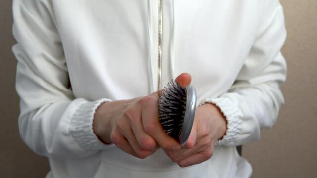 Close-up of the hair on the comb. The concept of hair loss. The hair remains on the comb after combing.