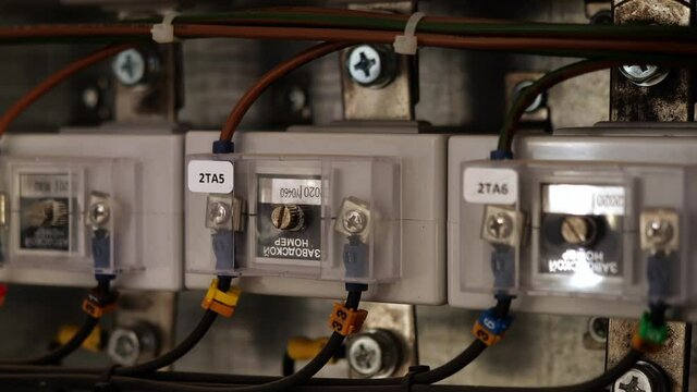 Row of modern key selector switches in plastic cases connected with cables on board in control room extreme close view