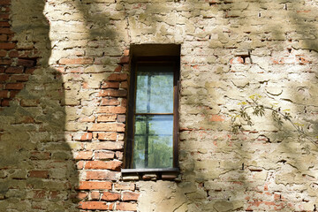Stare okna i otwory okienne w ceglanych ścianach.