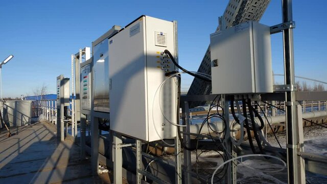 Control panels and switchboards on ground near reservoir with swirling water at contemporary purification station on winter day