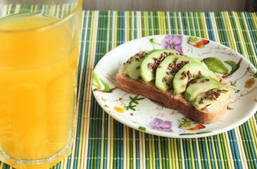sandwich with avocado and flax seeds and orange juice