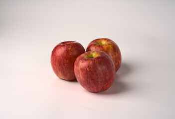 Three red juicy big apples on a white background.