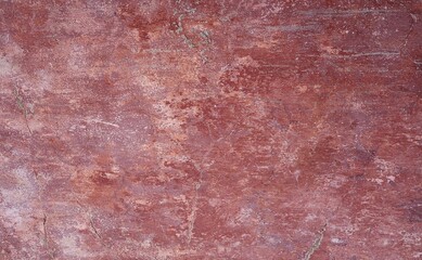 closeup of a distressed wall in pink and red shades 