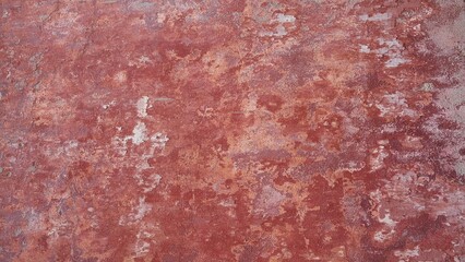 closeup of a distressed wall in pink and red shades 