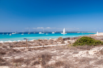 Obraz premium Luxury boats anchored near the beach of Ses Illetas. Wild beach on the island of Formentera, Spain