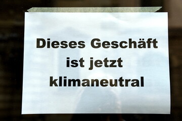 Schild in einem Schaufenster: "Dieses Geschäft ist jetzt klimaneutral" 