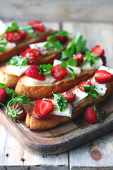 Fototapeta na wymiar Beautiful strawberry toast with white cheese. Strawberry bruschetta. A healthy summer snack.