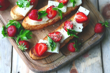 Beautiful strawberry toast with white cheese. Strawberry bruschetta. A healthy summer snack.