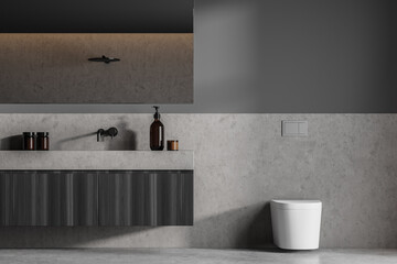 Grey bathroom interior with sink and white toilet on grey floor