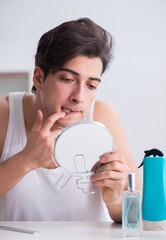 Young handsome man staring in the mirror