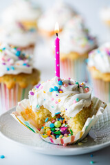 Close up of a lava confetti cupcake with other cupcakes in soft focus in behind. Birthday concept.
