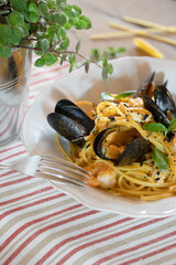 Pasta with seafood, pasta dish with seafood on the table with rosemary and cherry tomatoes, Italian food