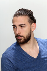 Attractive male model with long hair and beard posing in studio on isolated background. Style, trends, fashion concept.