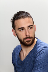 Fototapeta premium Attractive male model with long hair and beard posing in studio on isolated background. Style, trends, fashion concept.