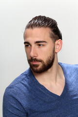 Obraz premium Attractive male model with long hair and beard posing in studio on isolated background. Style, trends, fashion concept.