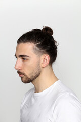 Fototapeta premium Attractive male model with long hair and beard posing in studio on isolated background. Style, trends, fashion concept.