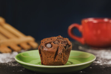 Homemade chocolate chips and vanilla muffin on a black background with sugar
