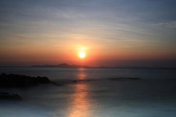 Obraz premium Long explosure sea wave with sun sun background