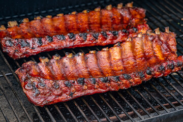 2 slabs of ribs smoking on grill outside