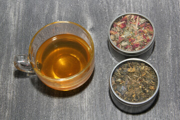 Tools for preparing herbal infusions: glass cup, infuser, spoon, dried dehydrated herb to relax or cure diseases
