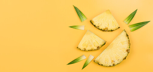 three pineapple slices and leaves on a yellow background. summer background