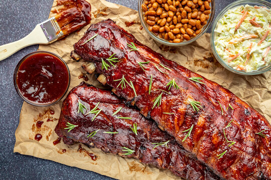 2 slabs of ribs with barbeque sauce on brown paper
