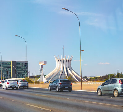 Catedral de Bras&iacute;lia vista em meio ao tr&aacute;fego de carros na cidade de Bras&iacute;lia. Foto para o conceito sobre tr&acirc;nsito no Brasil. Bras&iacute;lia, Distrito Federal - Brasil. Junho, 13, 2021.