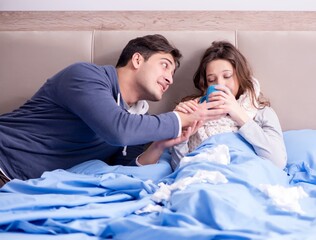 Wife caring for sick husband at home in bed