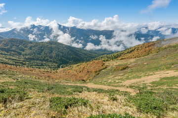 Fototapeta na wymiar Clouds above the mountains at autumn day time.