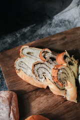Fresh homemade Loaf of bread with truffle with a chef holding gold knife for cut. Bakery gold rustic crusty loaves of bread and buns.