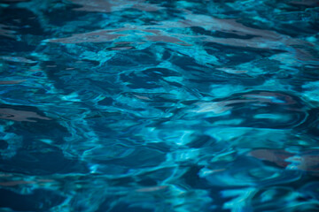 Abstract ripple wave and clear turquoise water surface in swimming pool, blue water wave for background and abstract design.