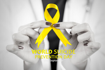 Hands of female doctor showing yellow ribbon