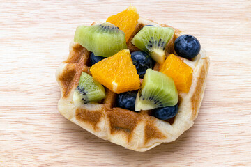 A piece of waffle and mixed fruits.