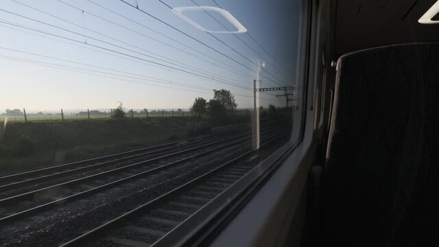 Looking out the window of high speed train at english countryside early morning empty seat