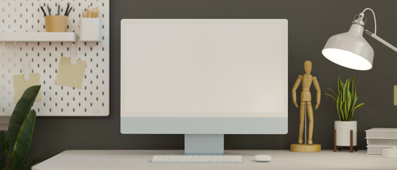 Computer monitor with mock-up screen in home office decorated with plant and shelf, 3D rendering