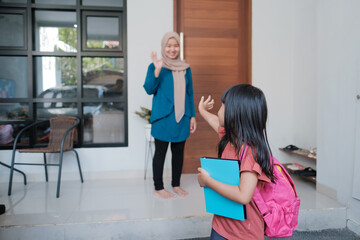 happy kid wave goodbye to mother before going to school in the morning
