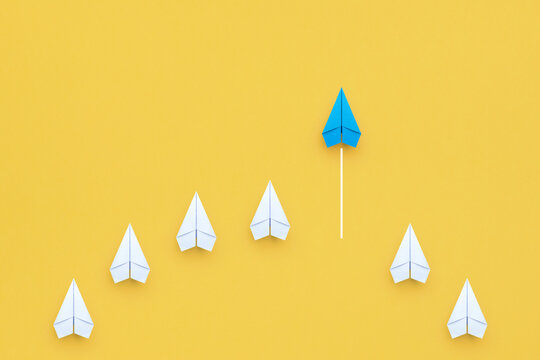 Business concept for new ideas creativity, innovative solution and Leadership concept with blue paper plane leading among white on yellow background