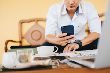 young businessman working and using smart phone and notebook computer in workplace.