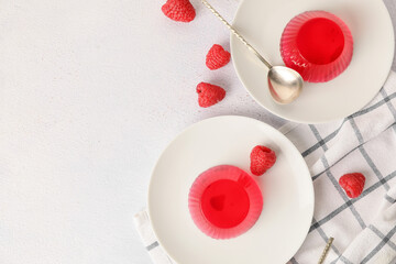 Obraz na płótnie Canvas Plates with tasty raspberry jelly on light background